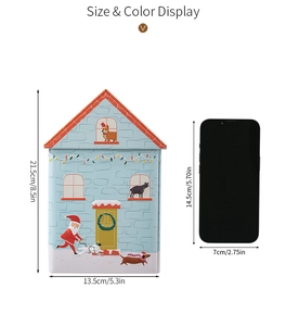 Size comparison of Christmas house tin box next to a mobile phone for scale