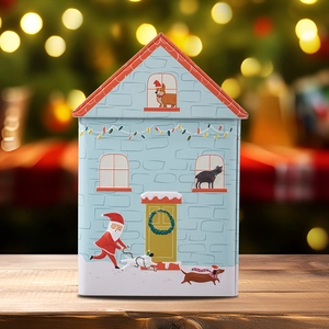 Detailed view of a blue dog house Christmas tin box on a wooden table with festive lights