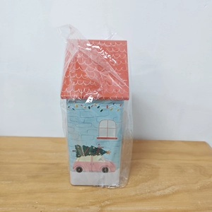 Detailed view of dog house tin box with Christmas tree graphics and red roof