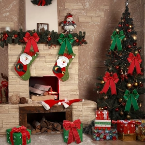 Detail of red and green glitter Christmas bows and festive stockings by a fireplace
