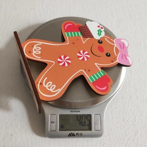 Wooden gingerbread man decoration weight measurement showing 40.5g on a kitchen scale