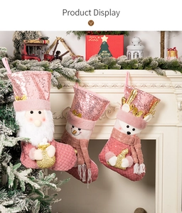 Calze di Natale rosa con paillettes, Babbo Natale e renna appese al camino decorativo