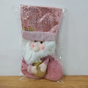 Dettaglio di una calza natalizia con paillettes rosa, Babbo Natale e stelle dorate