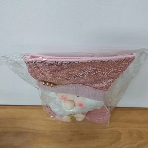 Dettaglio ravvicinato di una calza natalizia con paillettes rosa e Babbo Natale in confezione di plastica