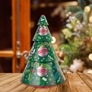 Detailed view of layered Christmas tree tin canister with festive ornaments on wood surface