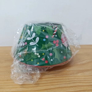 Detail of Christmas tree shaped tin box with festive leaf and candy patterns