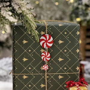 Three-tier red and white peppermint candy ornament hanging from a festive gift box