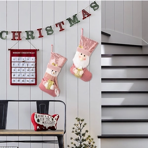 Calze di Natale rosa con paillettes, Babbo Natale e pupazzo di neve su parete in legno
