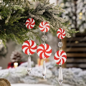 Set of 3 peppermint candy icicle ornaments hanging on a snowy Christmas tree branch