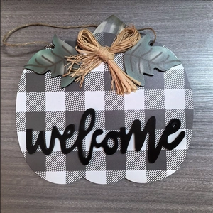 Détail de la plaque de bienvenue citrouille à carreaux avec feuilles et noeud en jute