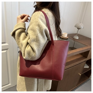 Close-up of vintage dark red tote bag in matte leather featuring visible stitching detail