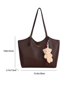 Large brown synthetic leather tote bag with shoulder strap and plush bear pendant detail