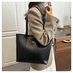 Detail of black leather tote bag with gold Fashion Bags lettering and thin shoulder straps
