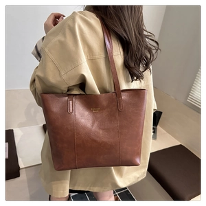 Detail of dark brown tote bag with FASHION BAGS gold lettering and vintage texture