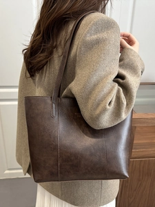 Large dark brown distressed leather tote bag shown on a model for daily commute use