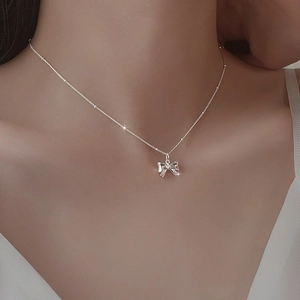 Elegante silberne Schleifen-Halskette an feiner Perlenkette für Damen am Hals