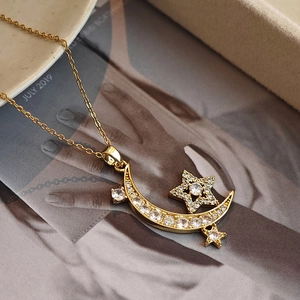Elegant gold moon and stars necklace with sparkling white zircon pavé on warm background