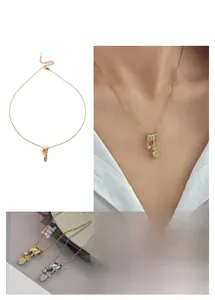 Detailed views of pineapple pendant necklace with sparkling diamonds and gold finish