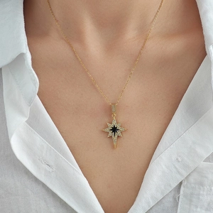 Elegant gold octagonal star pendant necklace with black center and sparkling pavé crystals
