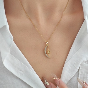 Minimalist gold moon and star pendant necklace featuring white cubic zirconia accents