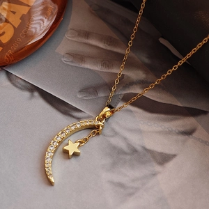 Elegant gold star and moon pendant necklace with cubic zirconia on a fashion magazine