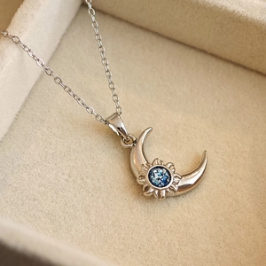Silver celestial necklace with crescent moon and sun pendant featuring blue stone inlay