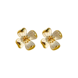 Vue détaillée des boucles d'oreilles fleurs dorées avec pétales en émail blanc