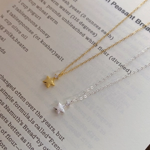 Detail of star pendant necklace in gold and silver finish with small zircon stones