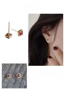 Macro detail of geometric square red zircon stud earrings with micro-inlaid gold plating