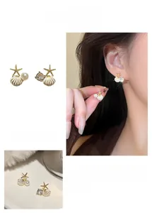 Détails de boucles d'oreilles étoile de mer et coquillage avec perles sur un mannequin