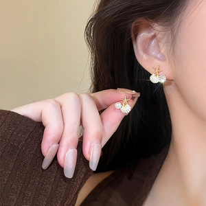 Boucles d'oreilles étoile de mer et coquillage avec perles dorées sur modèle