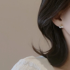 Boucles d'oreilles élégantes en forme d'étoile de mer et coquillage portées par un mannequin