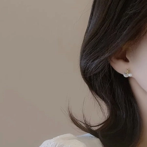 Boucles d'oreilles étoile de mer avec coquillage et perle portées par mannequin