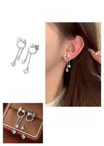 Détail de boucles d'oreilles papillon en perles avec pompons et zircons étincelants