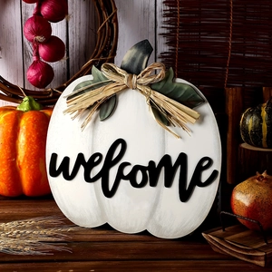 White wooden pumpkin welcome sign with raffia bow and greenery for autumn front door decor