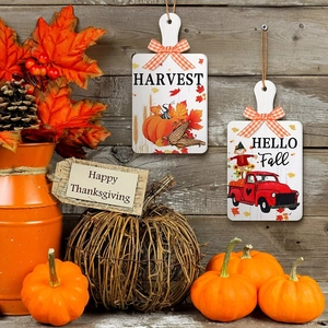 Macro detail of wooden harvest signs with plaid bows and pumpkin motifs for autumn decor
