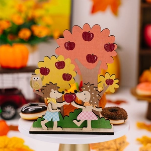 Detail of wooden hedgehog and apple tree desktop decor with layered autumn harvest theme