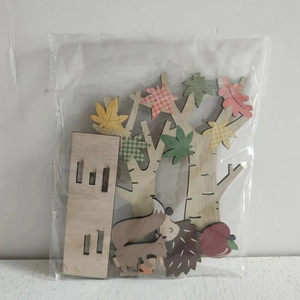 Macro detail of Thanksgiving wooden DIY forest animal pieces including hedgehog and apple tree