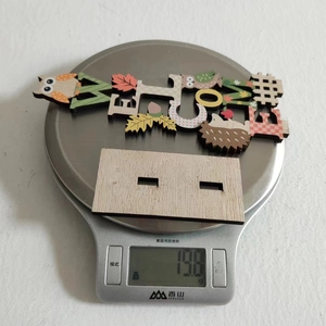Macro shot of a wooden owl harvest ornament on a scale weighing 19.8 grams for decoration