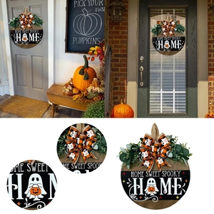 Dettaglio della targa Halloween HOME con foglie di eucalipto e fiocco a scacchi arancione