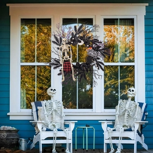 Detail of Halloween wreath with small skeleton and Happy Halloween sign on window