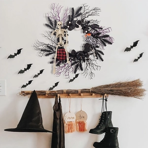 Halloween wreath detail with black pumpkin vine, skull and decorative wizard broom display