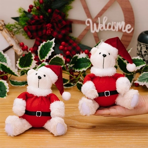 Detailed view of plush white Christmas bears in Santa outfits held as festive gift ideas