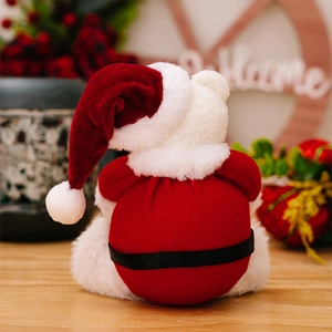 Rear view of a plush Christmas bear ornament with a red velvet hat on a wooden desk