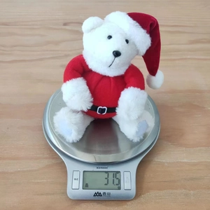 Detailed close-up showing the weight measurement of a cute Christmas teddy bear plush toy