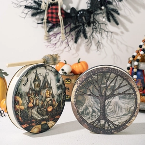 Close-up of Shaman drums with Halloween castle and Tree of Life designs and a drumstick