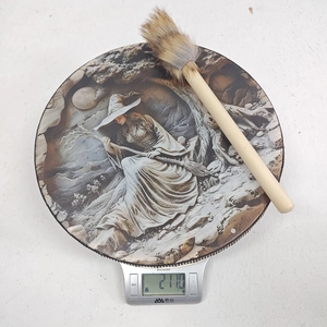 Top view of a round vintage shaman drum with witch illustration weighing 271g on a scale
