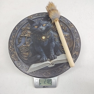 Detail of dark magic drum with black cat on old book and Celtic pattern frame