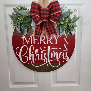 Close-up of a rustic Merry Christmas wooden sign hanging on a door with a buffalo plaid bow