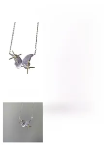 Detail of a purple butterfly necklace with gold starburst pendants on a silver chain